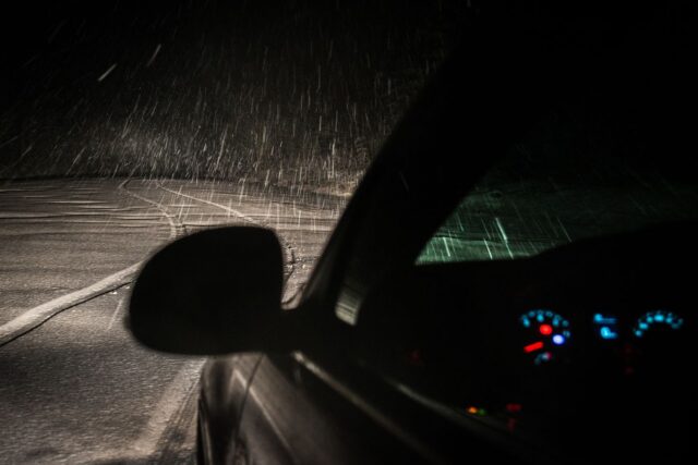 Bordul unei mașini cu mai mulți martori luminoși aprinși, văzut din spatele volanului la pornirea motorului
